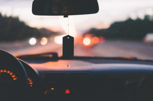 Sunset and road seen from interior of a car.
