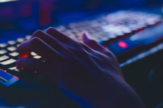 A person typing on a computer keyboard representing a charity donation scam