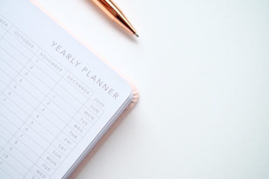 A yearly planner and a pen on a desk